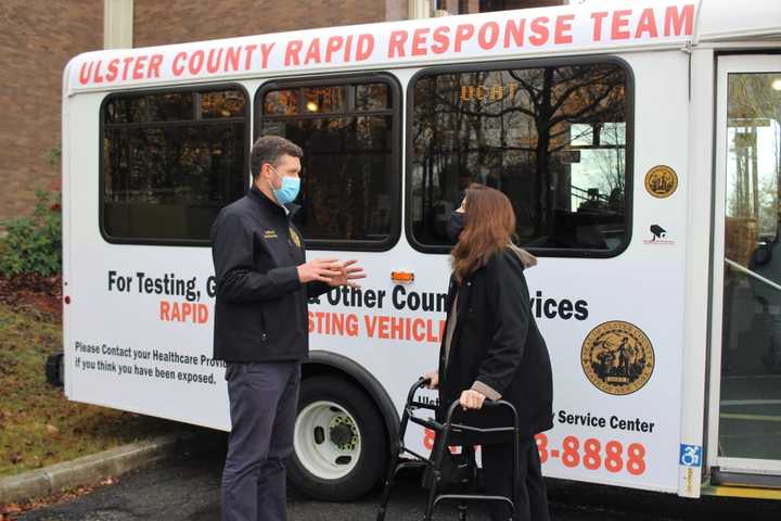 Pat Ryan speaking with a resident in front of the county&#x27;s rapid testing vehicle, which can process 8 tests in a day with results for each test in under 30 minutes.