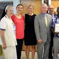 <p>Rockland County Executive Ed Day and nonprofit and community leaders pose with Frandy Osias-Louis Tuesday after the volunteer was presented with a Daily Point of Light award.</p>