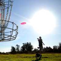 <p>Disc golf is played by throwing golf discs into baskets attached to poles.</p>