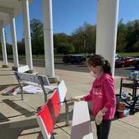 <p>A student paints a bench to show school spirit at Saxe Middle School.</p>