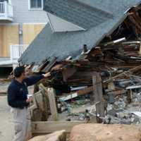 <p>A FEMA official inspects damage at a coastal home in Fairfield after Hurricane Sandy hit in 2012. </p>