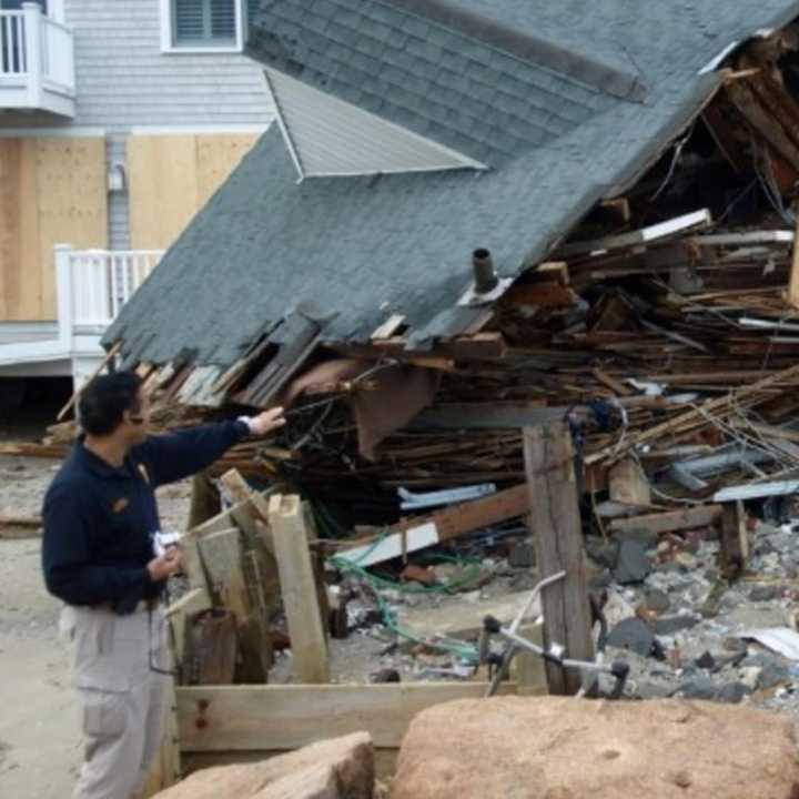 A FEMA official inspects damage at a coastal home in Fairfield after Hurricane Sandy hit in 2012. 