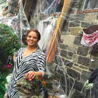 <p>Maria Bruno stands by her St. Roch Avenue home in Greenwich that she has covered in Halloween decorations.</p>