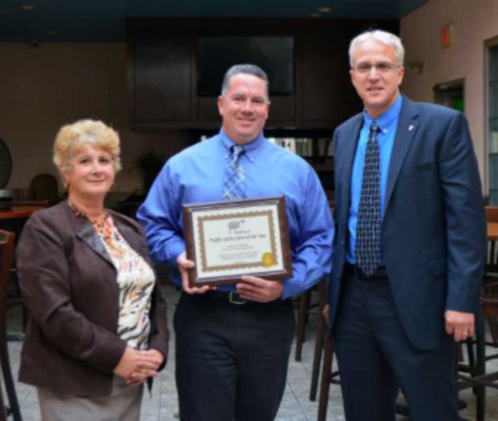 AAA Public Affairs Manager Fran Mayko, left, presents the Traffic Safety Hero Award to Officer Booth, center. On the right is Assistant Chief Tom Wuernemann.