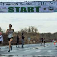 <p>Mary Zengo of Wilton strides across the finish line to win the women&#x27;s division of the Mima&#x27;s Meatball Mile for MSA Sunday in Danbury. </p>