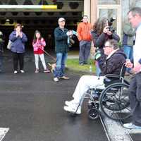 <p>JP Henson of Ridgefield, who has MSA, gets assistance from some runners at the start of the race.</p>