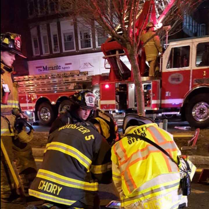 City and volunteer firefighters work at the scene of a Christmas evening blaze on Main Street in Danbury.