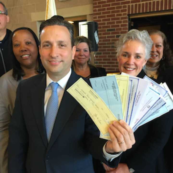 Senate Majority Leader Bob Duff (D-Norwalk) holds up checks totaling $17,150 for eight local nonprofits at the Norwalk Fire Department Station #2 on Connecticut Avenue. The donations came as a result of his annual holiday party.