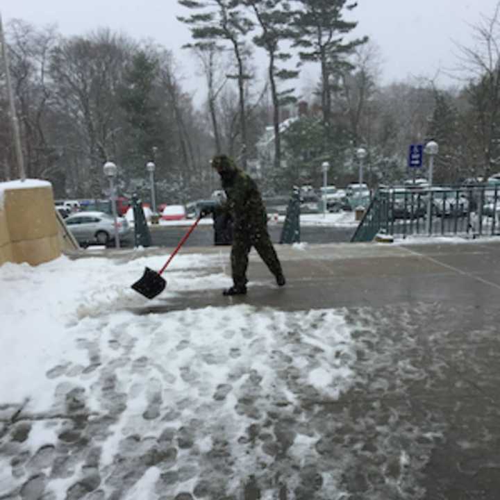 A man goes to work cleaning snow and slush from the Greenwich Library&#x27;s front entrance on Monday.