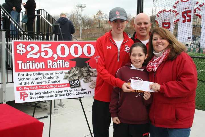 The Corcoran Family, winners of the 2015 raffle, purchase a ticket for this year’s raffle. Pictured are Mary and Chris Corcoran with children Matt and Ellie.