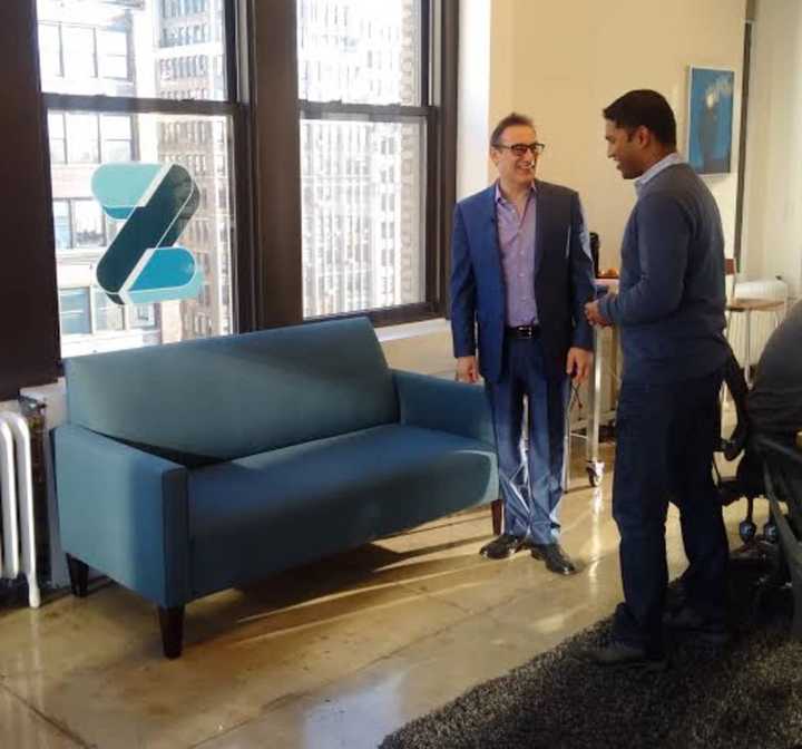 New Rochelle&#x27;s Rudy Callegari, left, talks to a Zootly employee in his New York office. Callegari started the business after getting frustrated in finding a mover for the blue loveseat to his right.