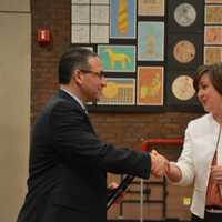 <p>Dr. Christopher Manno shakes hands with Bedford Central school board President Jennifer Gerken after the board voted to appoint him as schools superintendent.</p>