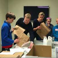 <p>Volunteers prepping grocery bags for a U.S. Postal Service food drive at Person to Person during Kyle A. Markes Day of Service April 16.</p>