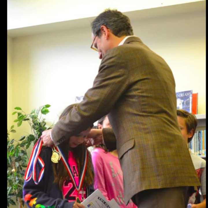 Greenwich United Way Board member Bill Finger presented medals to students at the North Mianus School Reading Champions Graduation ceremony.