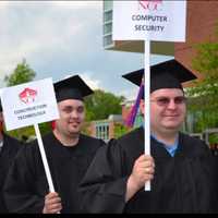 <p>Norwalk Community College graduates display signs with the names of the degrees they received.</p>