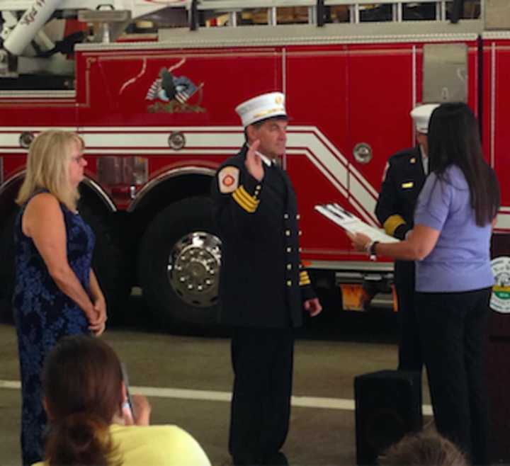 Wilton Town Clerk Lori Kaback, right, swears in Wilton Fire Department&#x27;s new Deputy Fire Marshal Kevin Plank. At left is Plank&#x27;s wife, Gale.