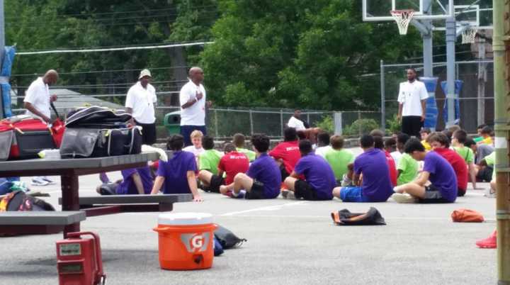 Young basketball players listen to instructors at a camp that included former NBA star Nate Archibald at White Plains Middle School.