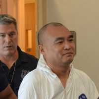 <p>Hengjun Chao, the suspect in Monday&#x27;s shooting at Lange&#x27;s deli in Chappaqua, is escorted by New Castle Police to his arraignment.</p>