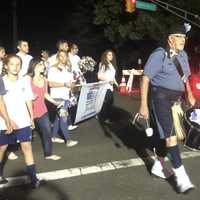 <p>Community members march behind the Police Pipes and Drums of Bergen County toward the Howland Memorial Grove in the Paramus Freedom Walk Sunday.</p>