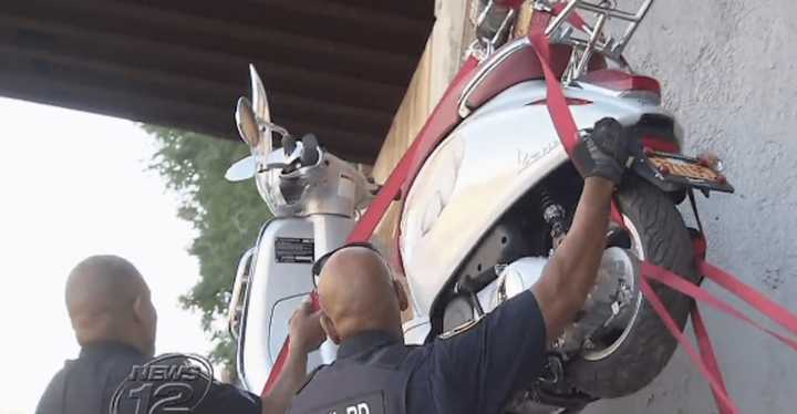 Hastings-on-Hudson police hoist a motorized scooter off the railroad tracks on Thursday morning.