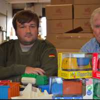 <p>Luke and his father Jim Barber with some of the trucks they make</p>