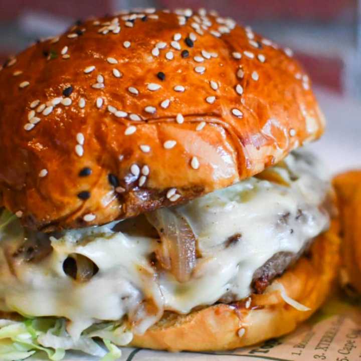 The Goombah, stuffed with sautéed mushrooms, Swiss cheese and caramelized onions. It&#x27;s topped with extra Swiss cheese, lettuce, and caramelized onions.