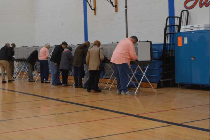 A steady stream of voters casts ballots on Tuesday in the gym at Danbury High School.