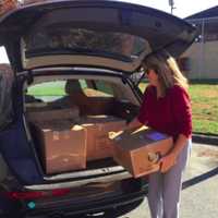 <p>A Glen Rock volunteer helps load boxes of candy into her car.</p>