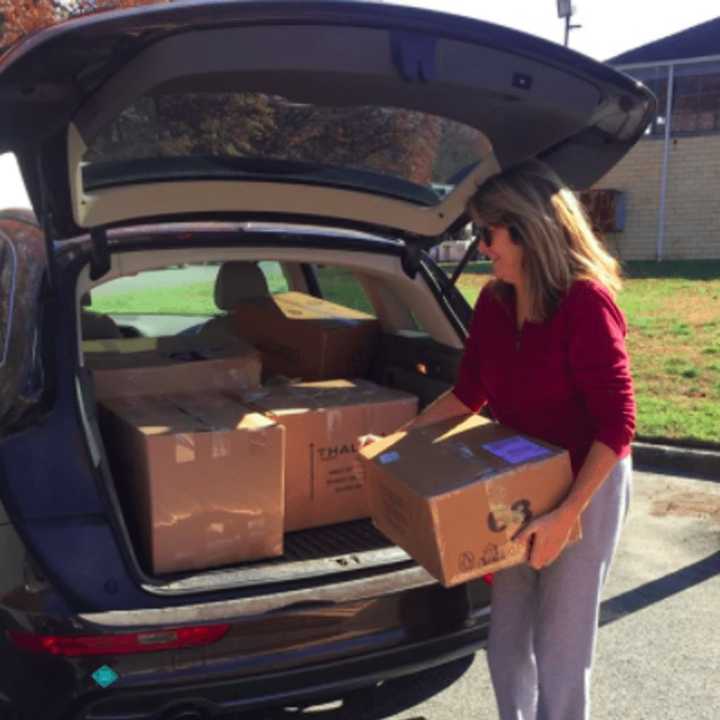 A Glen Rock volunteer helps load boxes of candy into her car.