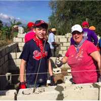 <p>From left, Danbury residents Cameron Tate and Heidi Barrios work on filling the mortar.</p>