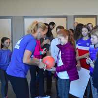 <p>Kristine Lilly signs soccer balls and gives autographs to kids after her talk.</p>