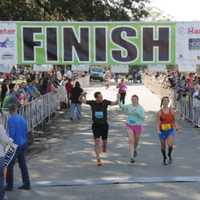 <p>Ryan Fox of Danbury, right, crosses the finish line at the Charleston Marathon in South Carolina, where he finished second.</p>