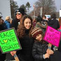 <p>Sophie, left, and Maddy Schwartz from Glen Rock hold signs promoting peace, love and unity.</p>