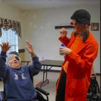 <p>Spark Arts owner, Cynthia Rauschert, dressed as a clown, working with seniors.</p>