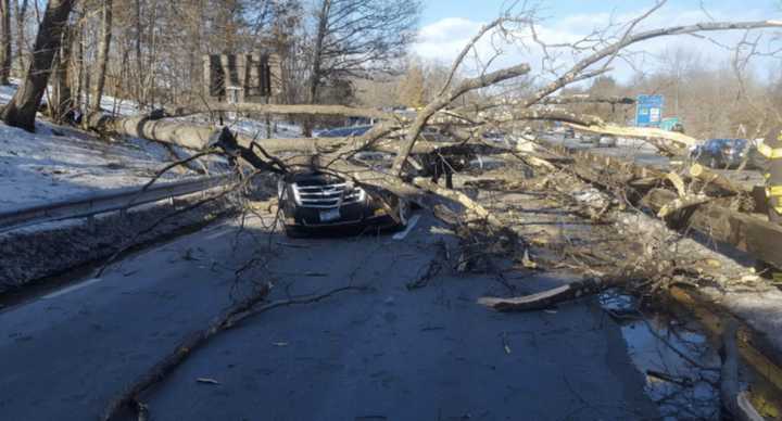 Debris from a fallen tree covers a car and blocks the southbound side of the Merritt Parkway in Greenwich on Monday.