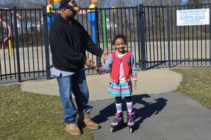 7-year-old Ashlee Evans with her father Rodney Evans, enjoying the summer-like weather Friday afternoon at Rogers Park in Danbury