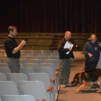 <p>A K-9 team searches for potential explosives in the auditorium at Staples High School.</p>