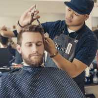 <p>Flores works on a client in his Teaneck barbershop.</p>