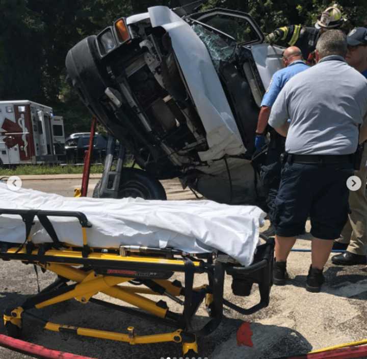 EMS and fire officials work to remove a person entrapped in a van following a crash.