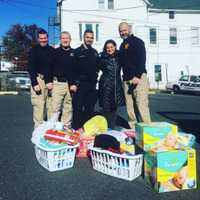 <p>Members of the Dumont Police Department and Daily Voice managing editor Cecilia Levine prepare to bring some supplies to the Roman family Tuesday.</p>