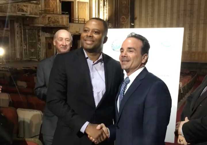 Exact Capital Managing Partner Craig Livingston, center, and Bridgeport Mayor Joe Ganim, right, shake hands as Bridgeport Economic Development Director Tom Gill, left, looks on.