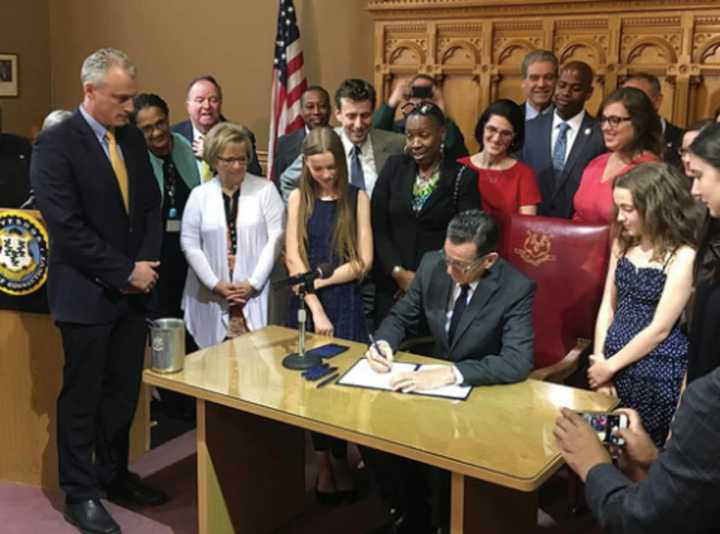 Gov. Dannel P. Malloy signs legislation on pay discrimination.