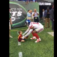 <p>Beckham helps Cole stand up after tripping over the ball.</p>