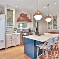 <p>The kitchen features a copper hood, marble island and and restaurant-quality range.</p>