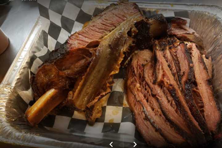 Flintstones-Style 11-Inch Dinosaur Rib Signature Dish At Lake Ronkonkoma's Rolling Smoke Grill