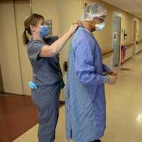 <p>Van Bever helps Dr. Suraj Suggar prepare for another day of work.</p>