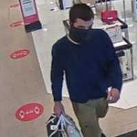 <p>One of the two unidentified thieves, stolen purses in hand.</p>