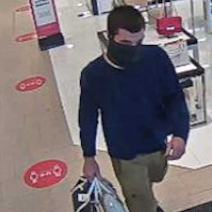 One of the two unidentified thieves, stolen purses in hand.