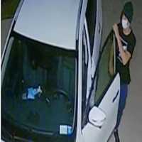 <p>The unidentified thief caught breaking into a car on surveillance footage</p>