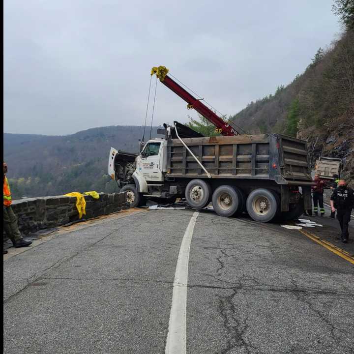 A dump truck almost went over a mountain and into the river below after crashing into a rock retaining wall.